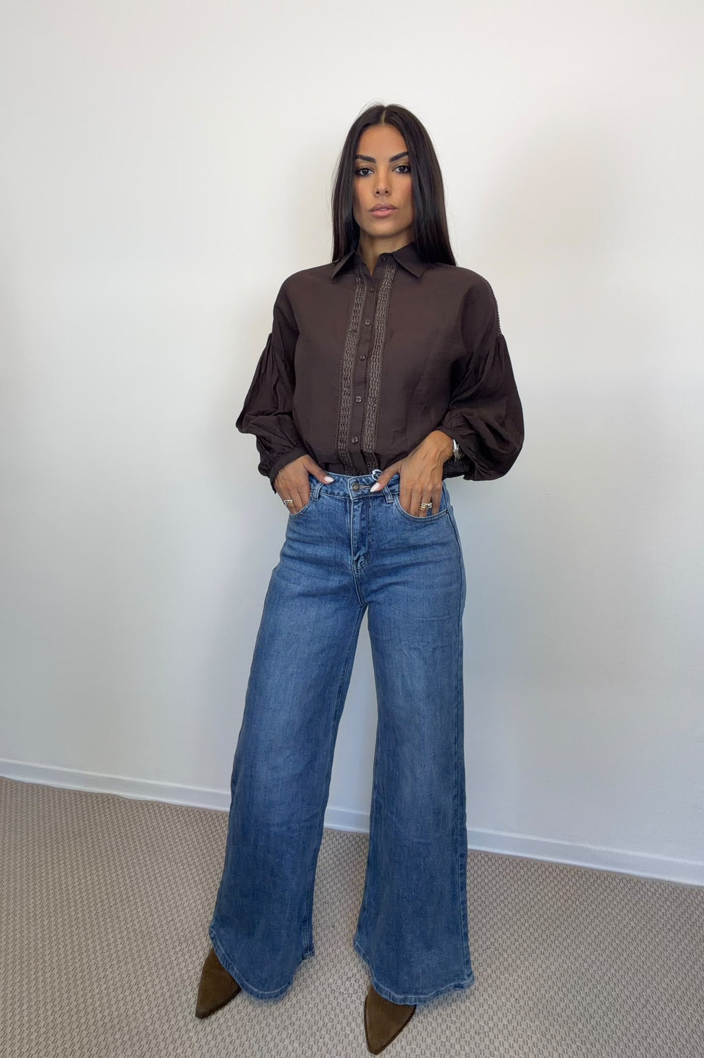 Camicia marrone con maniche ampie e bottoni frontali, indossata.