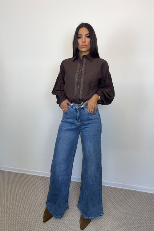 Camicia marrone con maniche ampie e bottoni frontali, indossata.