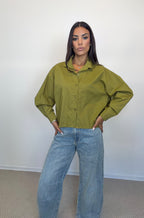 Camicia crop verde e jeans barrel in lavaggio chiaro, dettaglio frontale.