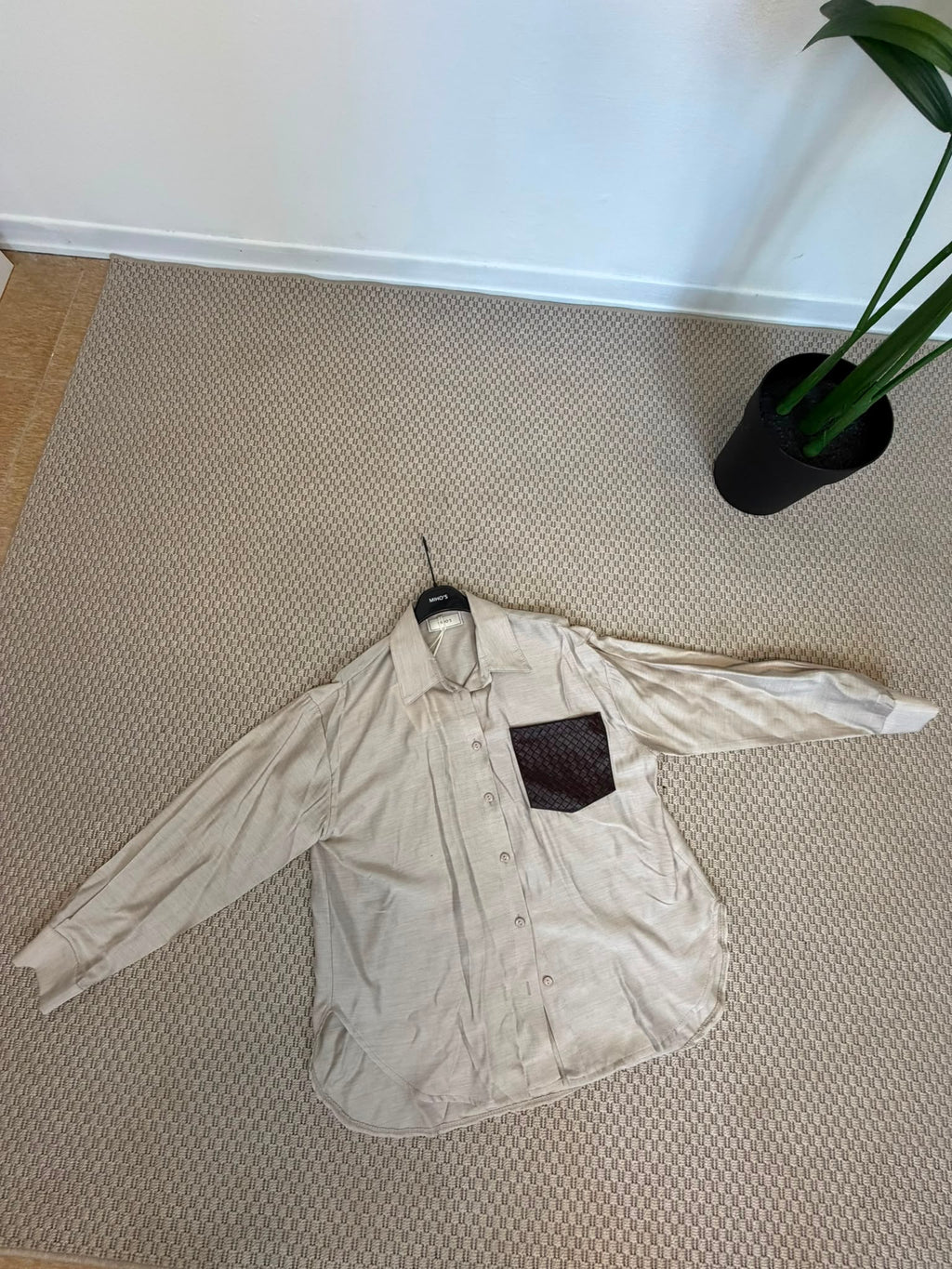 Camicia beige del coordinato Riviera con maxi tasca scura intrecciata a contrasto, vista frontale.