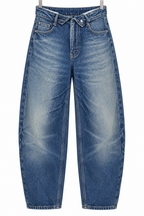 Jeans fold-over asimmetrico — vista intera non indossata su sfondo bianco