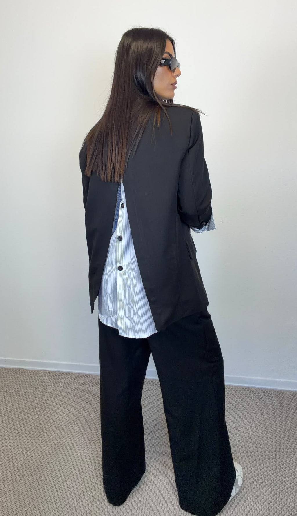 Giacca Lumina nera con inserto bianco sul retro e pantaloni neri, vista posteriore.
