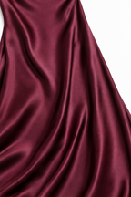 Abito elegante bordeaux, dettaglio del raso e delle sue pieghe.