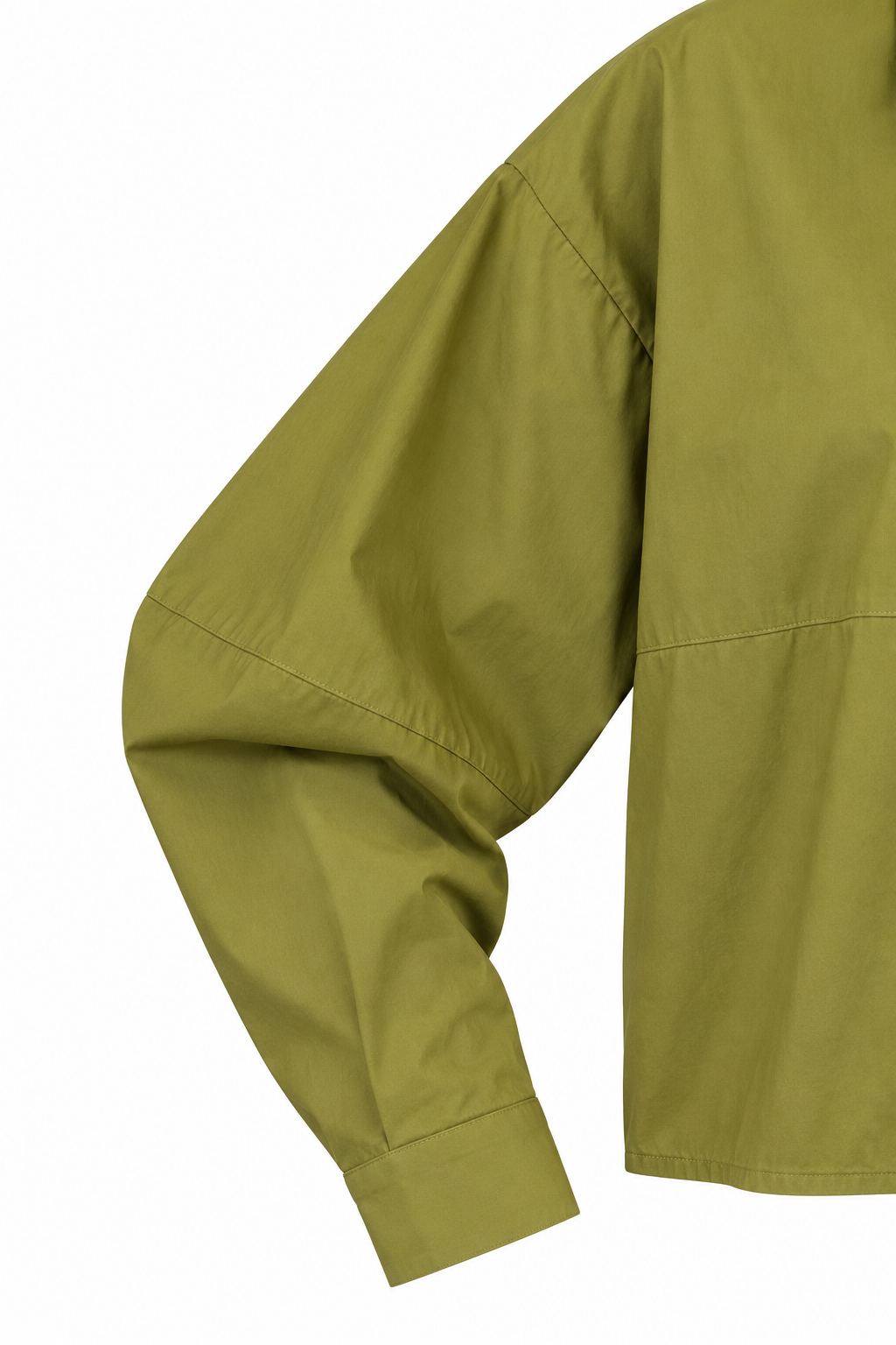 Camicia crop verde, dettaglio della spalla scesa, della cucitura trasversale e del polsino.