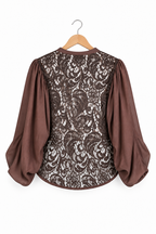 Camicia marrone con pizzo, vista posteriore intera non indossata su gruccia con maniche ampie e orlo curvo.