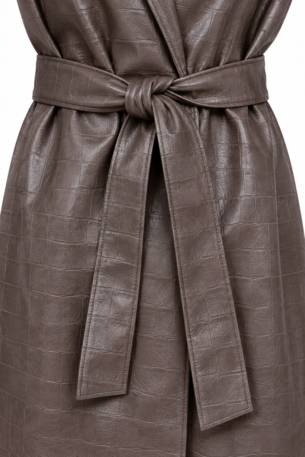 Dettaglio della cintura annodata del cappotto marrone effetto pelle.