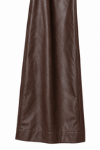 Dettaglio della gamba ampia e dell'orlo del pantalone marrone effetto pelle.