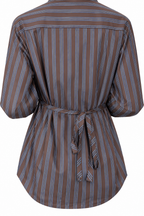Camicia marrone a righe blu del completo, vista posteriore parziale con laccetto e orlo arrotondato.