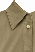 Dettaglio del colletto e del bottone della camicia verde.