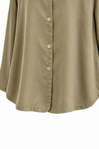 Dettaglio del fondo della camicia verde.