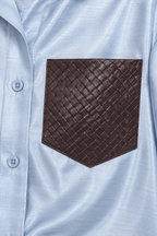 Dettaglio della tasca intrecciata sulla camicia azzurra del coordinato Riviera.