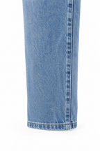 Jeans in cotone elasticizzato blu denim, dettaglio dell’orlo e della gamba.