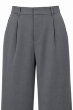 Dettaglio della vita e delle pieghe del pantalone palazzo grigio.