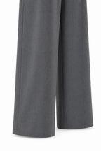 Dettaglio degli orli del pantalone palazzo sartoriale grigio.