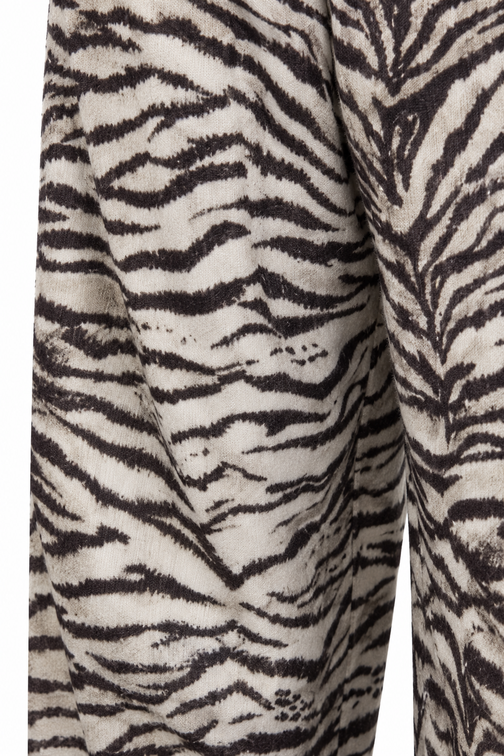 Dettaglio della stampa del pantalone zebra, su fondo bianco.
