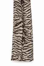 Dettaglio del fondo gamba e dell’orlo del pantalone zebra, su fondo bianco.