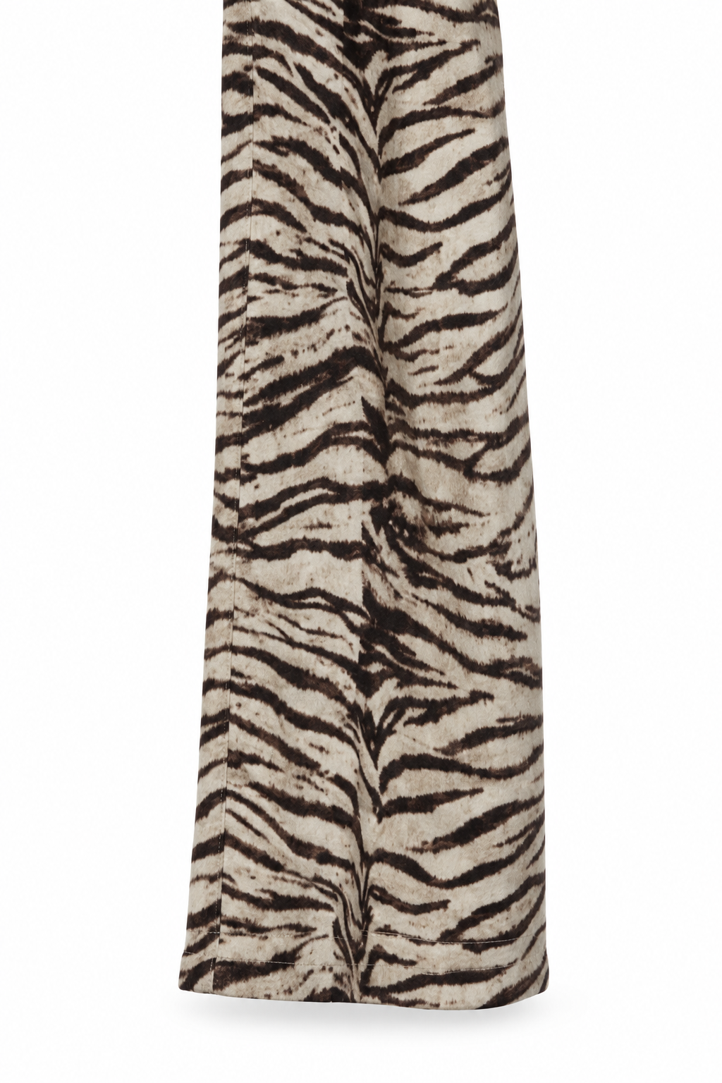 Dettaglio del fondo gamba e dell’orlo del pantalone zebra, su fondo bianco.