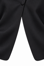 Tailleur coreano nero, dettaglio dell’incrocio anteriore e del bordo curvo della giacca.