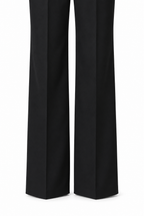 Tailleur doppiopetto nero, dettaglio della parte inferiore dei pantaloni su fondo bianco.