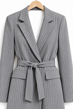 Tailleur gessato grigio non indossato, dettaglio dei revers e delle tasche della giacca.