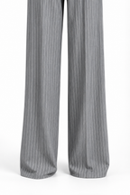 Tailleur gessato grigio non indossato, dettaglio delle gambe ampie e degli orli dei pantaloni.